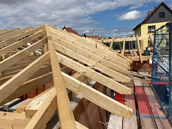 Zimmerarbeiten am Dachstuhl mit sichtbaren Verbindungen auf dem Gerüst
