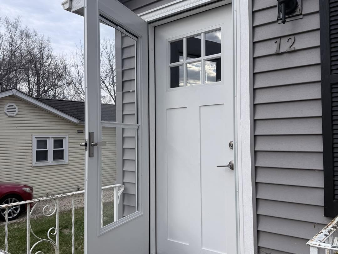 New white craftsman entry door with storm door installed by Fisher Remodeling