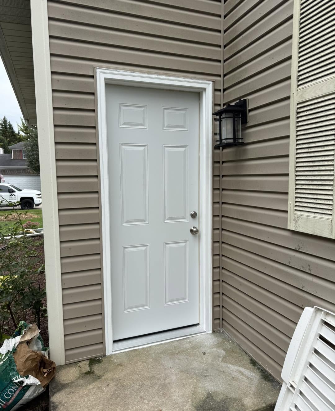 New white six-panel service door with storm trim by Fisher Remodeling