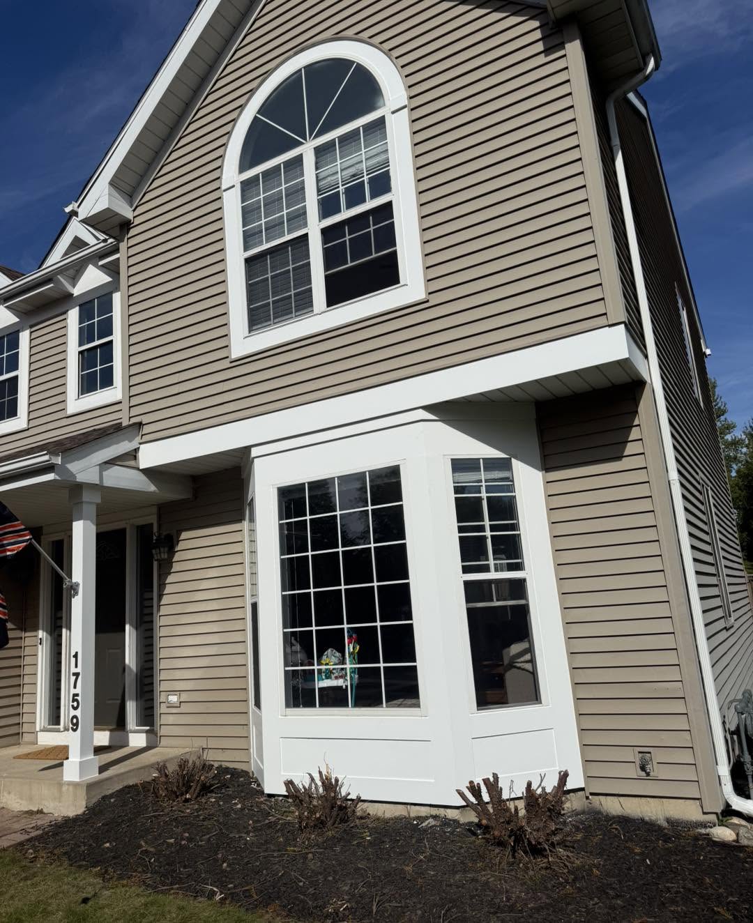Bay window replacement with white trim and arch top window by Fisher Remodeling