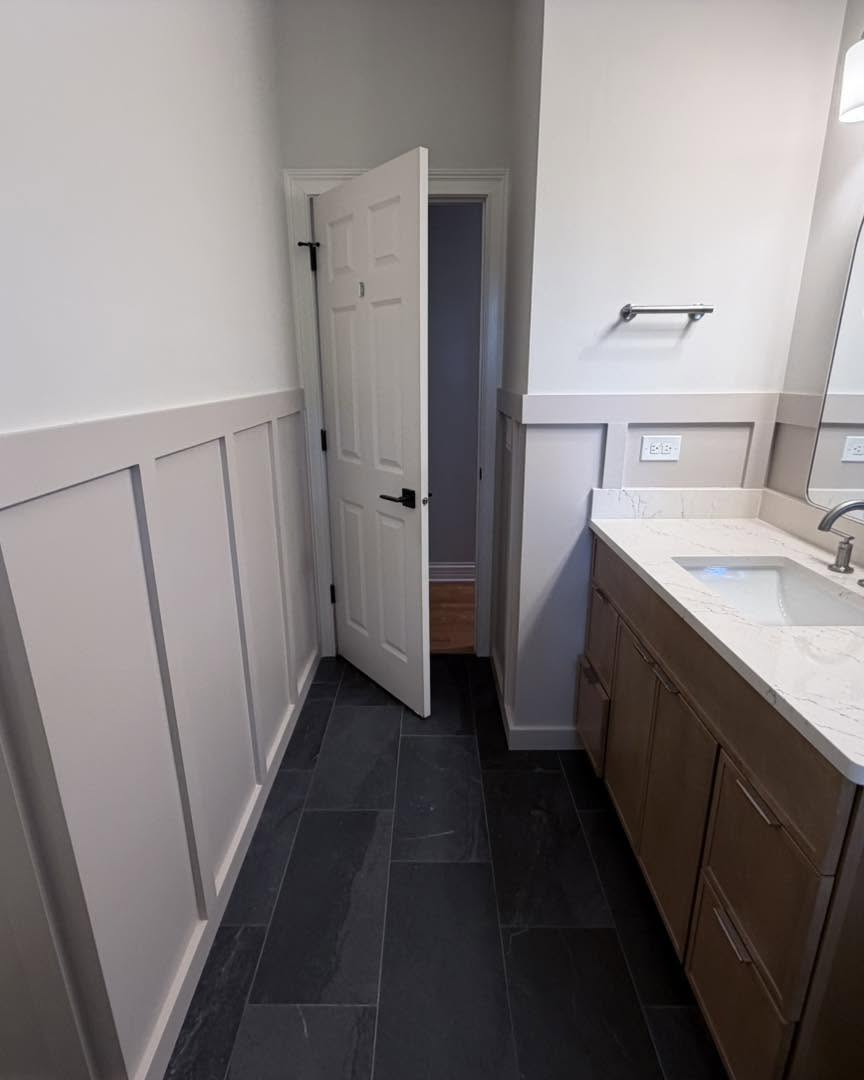 Board and batten wainscoting with slate tile flooring by Fisher Remodeling