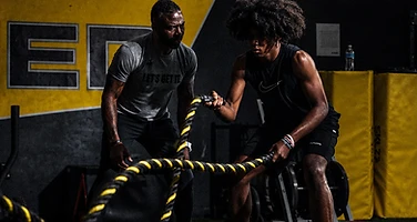 Athletes training with battle ropes