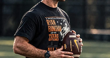 Athlete holding football on the field