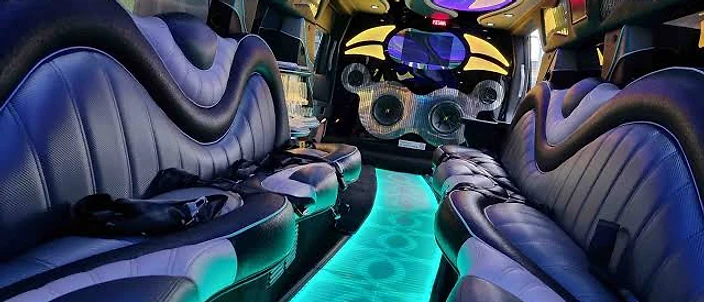 Limousine interior with leather seating and a turquoise illuminated aisle