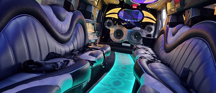 Limousine interior with leather seating and a turquoise illuminated aisle