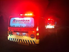 Two Guardian EMS ambulances responding at night with emergency lights