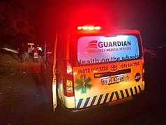 Guardian EMS ambulance at night with emergency red lights activated