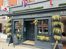 Exterior of Cheshire Tap freehouse in Altrincham, with hanging baskets and chalkboard sign