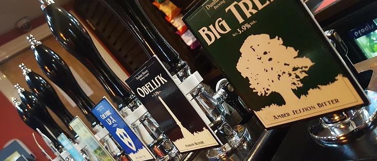 Close-up of beer handpumps at Costello's Bar, featuring Dunham Massey Brewing Company pump clips
