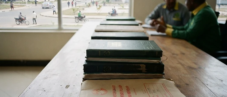 Official party membership enrollment ledgers and stamped disciplinary files sit on a wooden desk inside the CCM regional secretariat office in Dodoma.