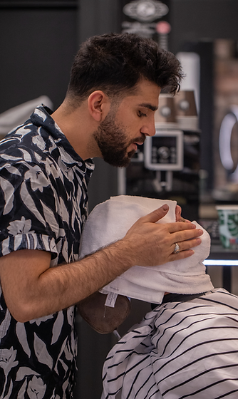Twana, barber and owner, cutting a customer’s hair at Magic Barbers in Bergen