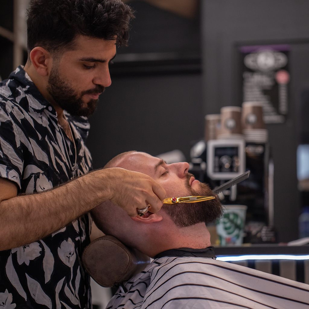 Twana trimming a customer’s beard at Magic Barbers