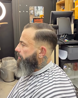 Side-parted men’s haircut with a long, well-groomed beard