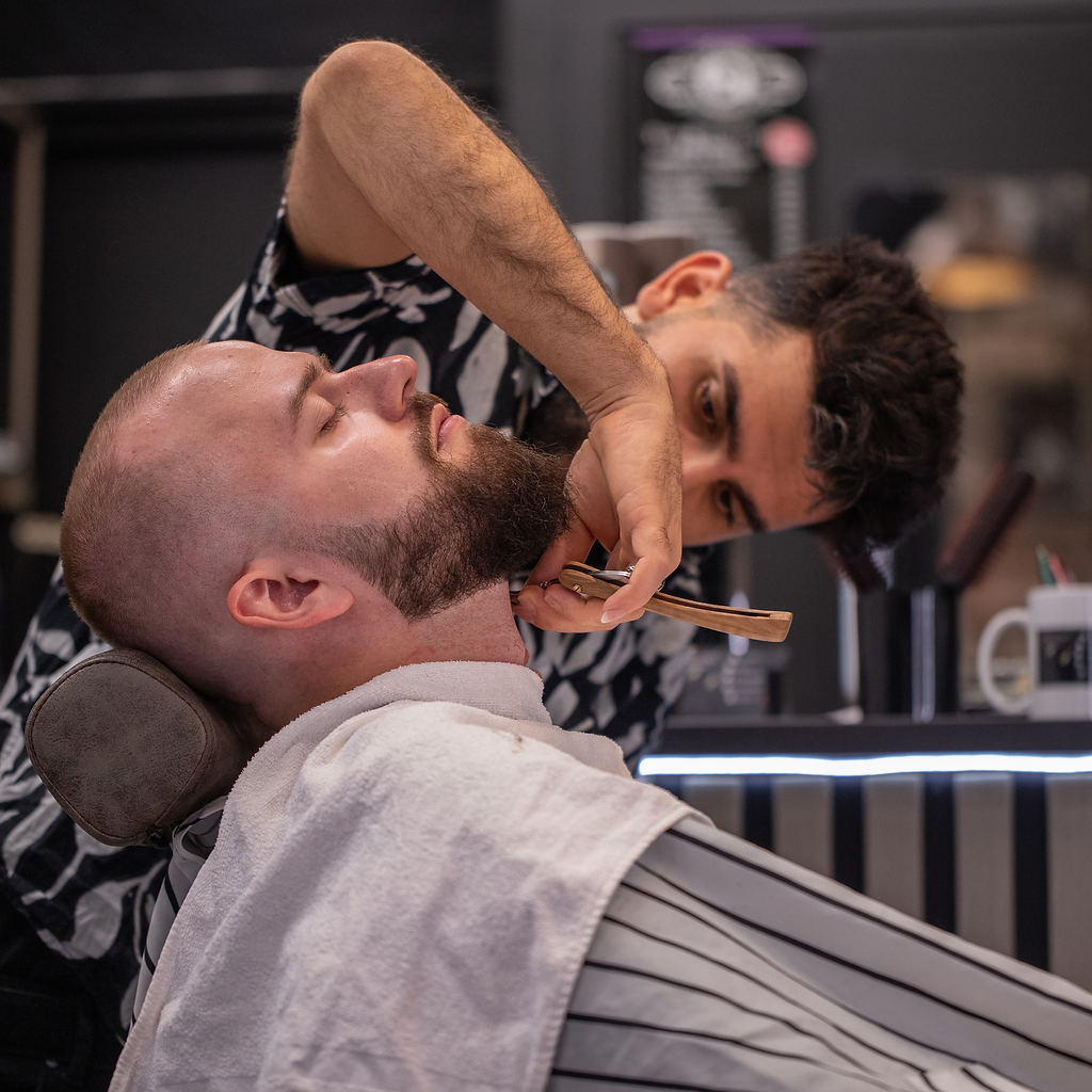 Barber working with a customer in the chair at Magic Barbers