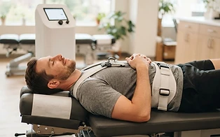 A relaxed patient receiving lumbar spinal decompression therapy on a computerized decompression table