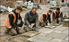 A senior landscaper directing a mini-digger on a build site