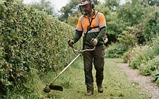 A gardener wearing safety gear while operating equipment