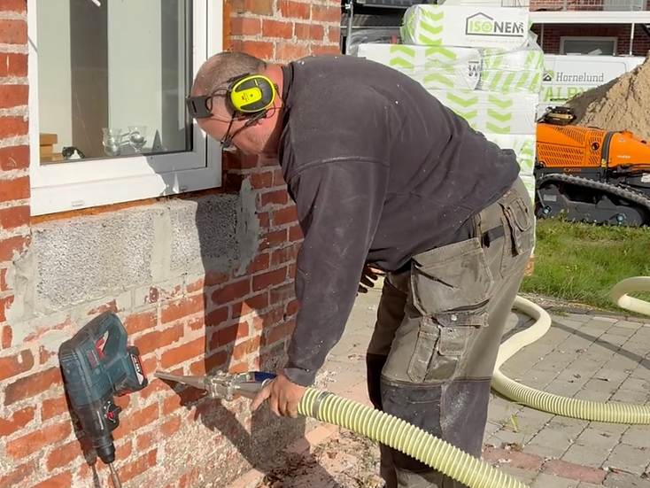 Indblæsning af isolering i hulmur gennem slange