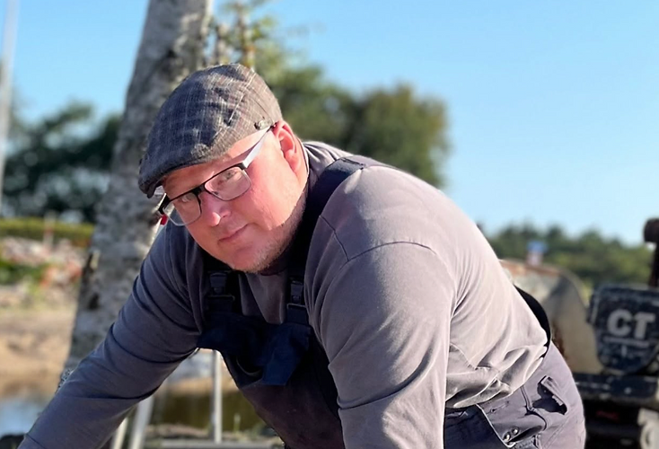 Jeppe Sand fra Sand Isolering i arbejdstøj på en arbejdsplads