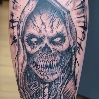 Black and grey tattoo of a hooded skeletal reaper with glowing white eyes, sharp teeth and an inverted cross on its chest, inside a spiked halo