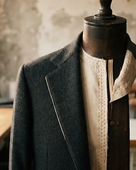 Detalle de la soltera y el entretela cosido a mano de una chaqueta de sastre de lana sobre un maniquí en un atelier minimalista