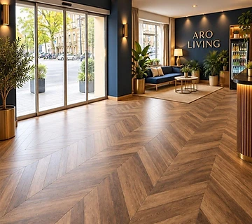 Bright ARO Living entrance hall with herringbone wood floor and lounge sofa
