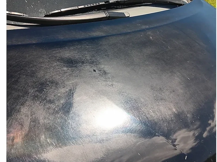 Swirl marks, scratches and road grime on a black hood before paint correction in La Crosse, WI