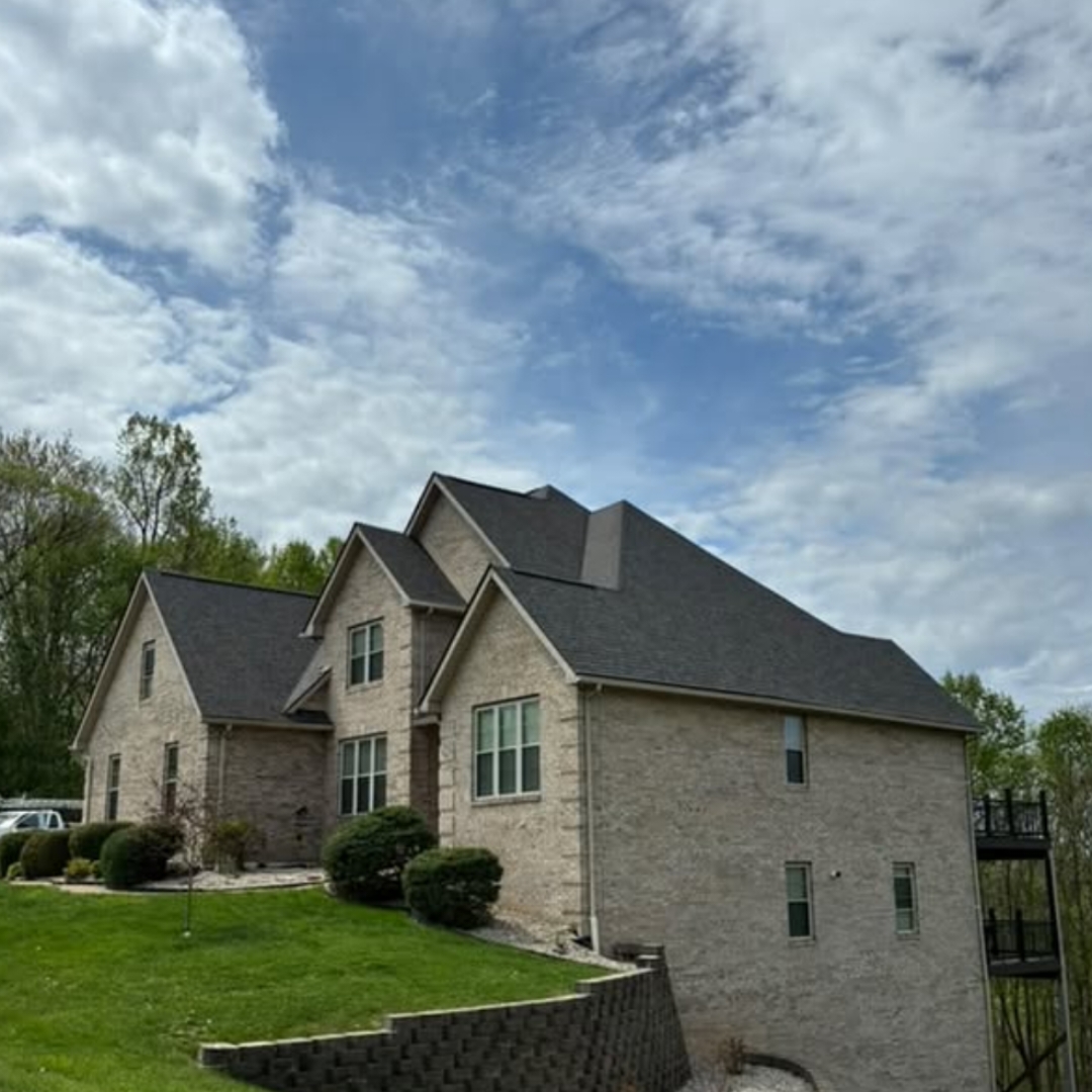 Completed shingle roof replacement on a large light brick estate