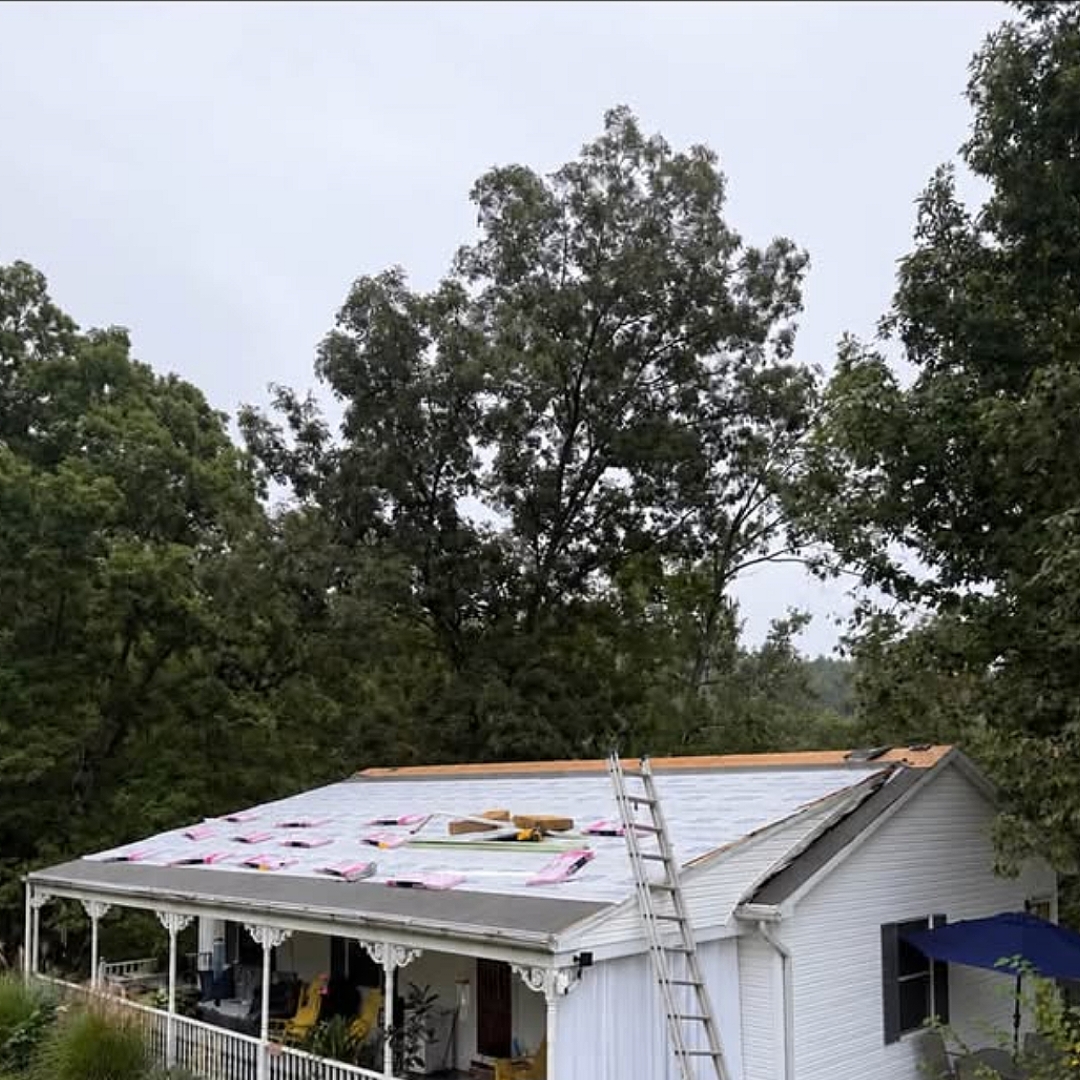 Roof tear-off and new underlayment on a white sided home