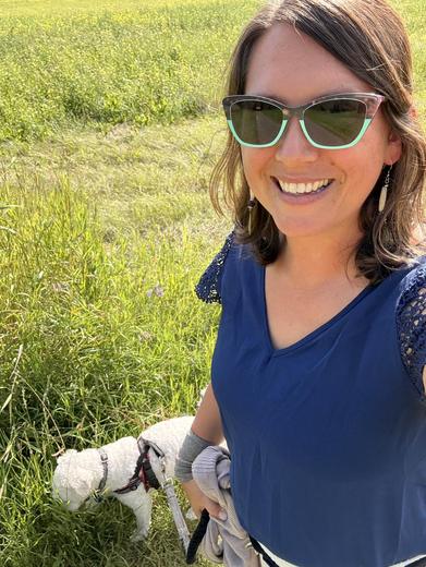 Dr. Alex in a summer field with her dog