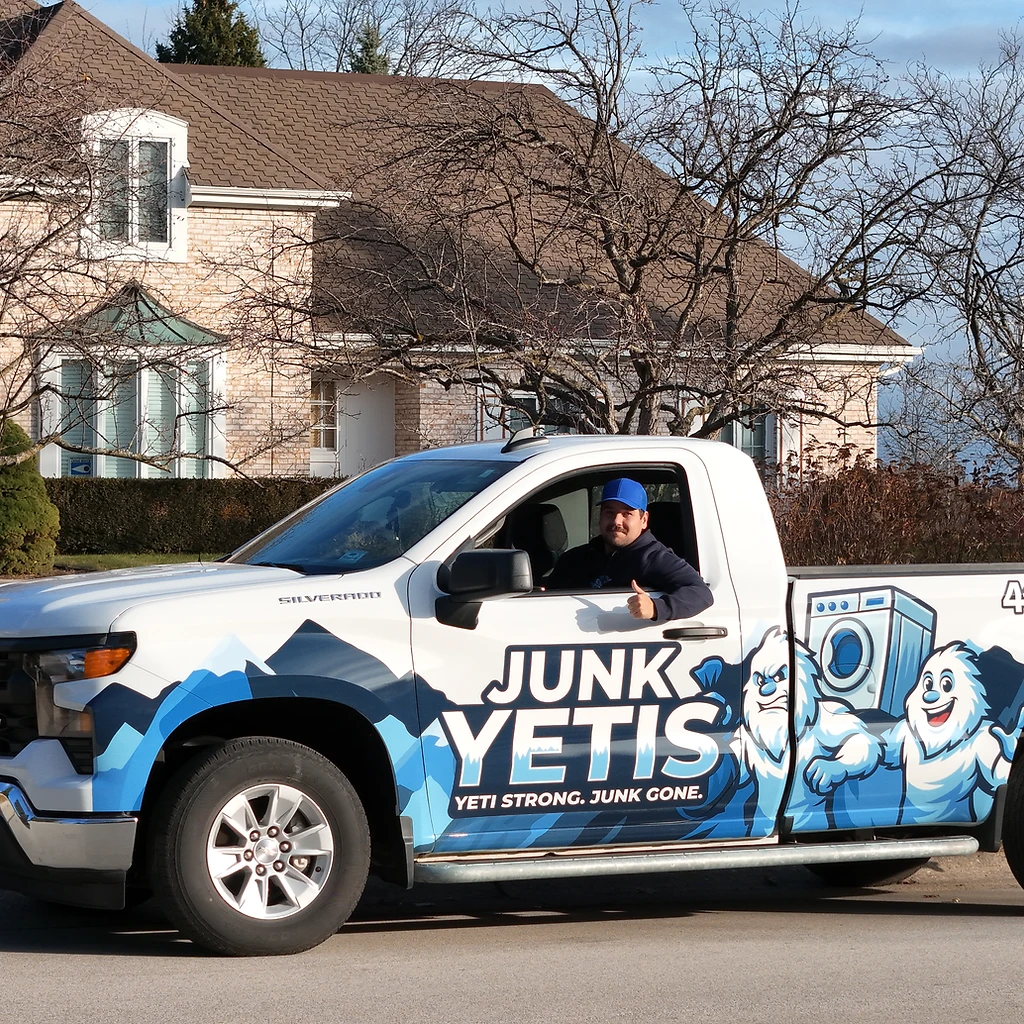 Junk Yetis branded pickup truck with blue Yeti wrap outside a Wisconsin home