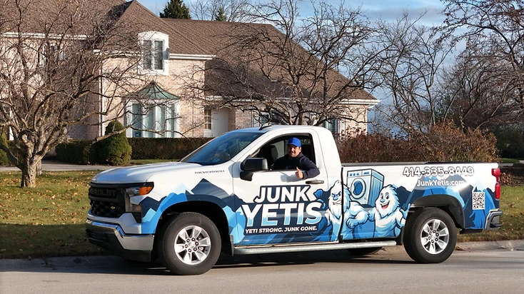 Junk Yetis branded pickup truck with blue Yeti wrap outside a Wisconsin home