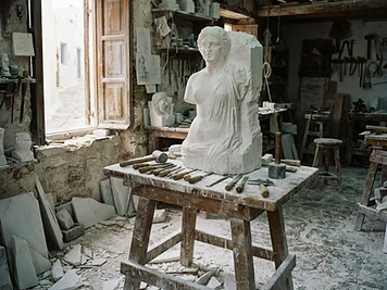 A half-carved marble figure, chisels and marble dust in a sculptor’s workshop on Tinos.