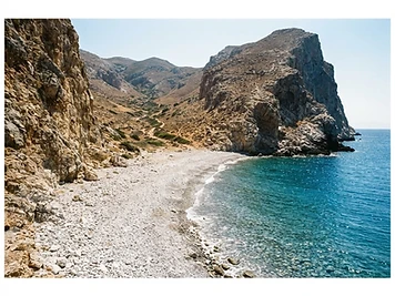 The remote pebble beach at Katergo on Folegandros, enclosed by bare cliffs.