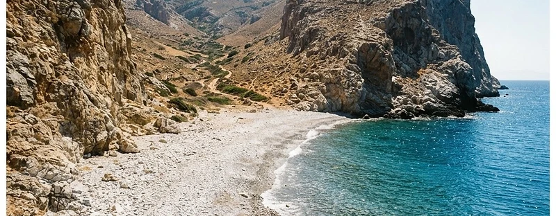 The remote pebble beach at Katergo on Folegandros, enclosed by bare cliffs.