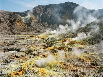 The floor of the Stefanos crater on Nisyros: pale grey ash, yellow sulphur crusts and steam venting from cracks.