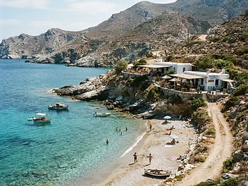 The small cove at Agali on Folegandros with tavernas on the low cliff behind the beach.