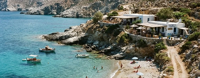 The small cove at Agali on Folegandros with tavernas on the low cliff behind the beach.