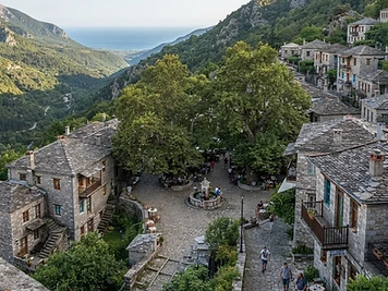 Stone houses with slate roofs under enormous plane trees in the square at Tsagarada on the Pelion peninsula.