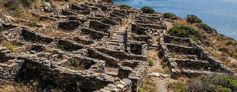 The low stone walls of the prehistoric settlement at Poliochni on Lemnos, on a dry hillside above the sea.