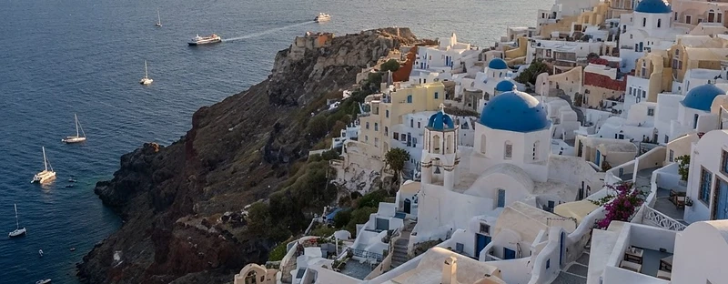 Santorini caldera village with blue domes above the Aegean