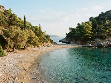 The small pebble and sand bay at Stafylos on Skopelos, flanked by pine-covered slopes.