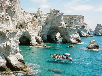 White volcanic cliffs, arches and sea caves rising from turquoise water at Kleftiko, Milos.