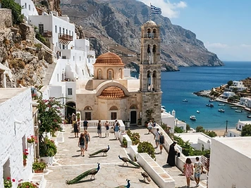 The whitewashed courtyard and red-domed church of the monastery at Panormitis on the south coast of Symi.