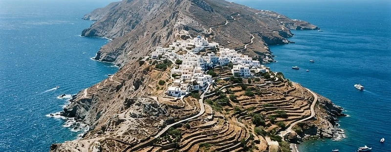 The long mountain ridge of Karpathos, bare rock and scrub with a small white village on the saddle and the sea either side.