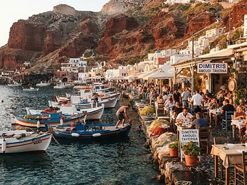 Fishing boats and waterside taverna tables at Amoudi Bay below Oia, Santorini.