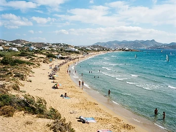The long golden sand and clear shallow water of Chrissi Akti beach on Paros.