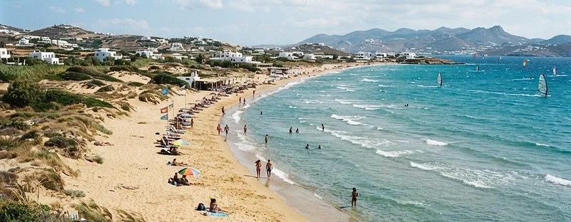 The long golden sand and clear shallow water of Chrissi Akti beach on Paros.