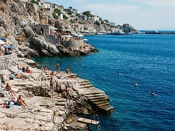 Flat limestone swimming platforms and bathing steps at the water's edge on Hydra.