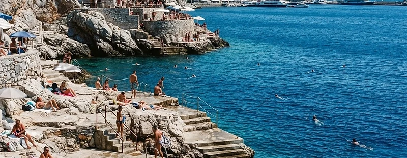 Flat limestone swimming platforms and bathing steps at the water's edge on Hydra.